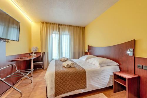 a hotel room with a bed and a desk at Logis Hotel Center in Brest