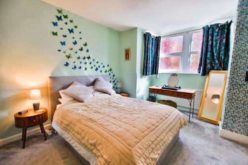 een slaapkamer met een bed, een tafel en ramen bij Welcome to Nelson's Quarters in Hastings