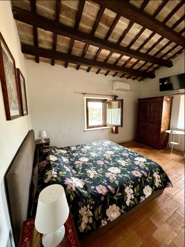 a bedroom with a bed with a floral blanket at Leoncito del Conero in Marcelli
