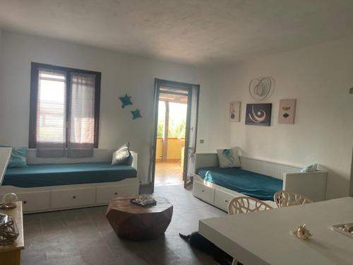 a living room with two beds and a table at Sa Jaga Brujada Residence - Simar Vacanze in Porto Rotondo