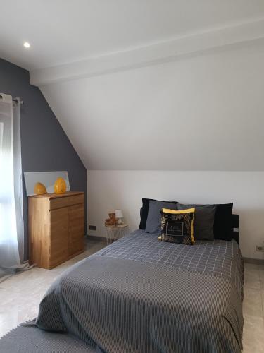 - une chambre avec un grand lit et une commode en bois dans l'établissement Le Studio D'Edouard, à Urschenheim