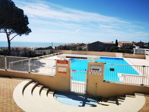 une piscine entourée d'une clôture blanche. dans l'établissement Maison de vacances climatisée, à Saint Pierre La Mer