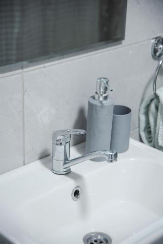 a sink with a faucet and a cup on it at Apartmani Maslačak in Vrdnik