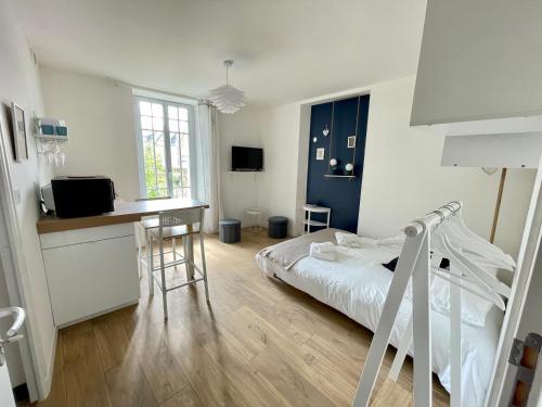 une chambre avec un lit et un bureau et une cuisine dans l'établissement STUDIO parfaitement agencé, à Lamballe