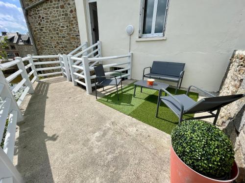 un patio avec des chaises et une table et une clôture dans l'établissement STUDIO parfaitement agencé, à Lamballe