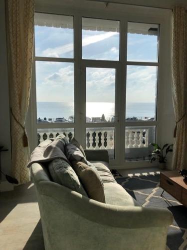 a couch in a living room with a large window at Beach Comber - Hastings in Hastings
