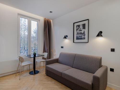 un salon avec un canapé et une table dans l'établissement Charming Studio in Pantin, à Pantin