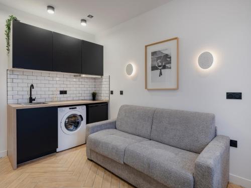 un salon avec un canapé et une machine à laver dans l'établissement Pretty Studio in Pantin, à Pantin