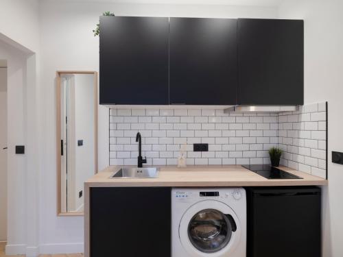 une cuisine avec une machine à laver et un évier dans l'établissement Pretty Studio in Pantin, à Pantin