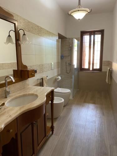 a bathroom with a sink and a toilet and a mirror at villamorus in Santa Maria la Palma