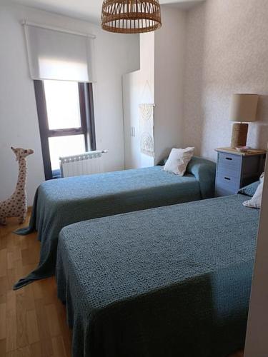 ein Schlafzimmer mit zwei Betten und einer Giraffe darin in der Unterkunft Apartamento Sweet Carolinas in Vilagarcia de Arousa