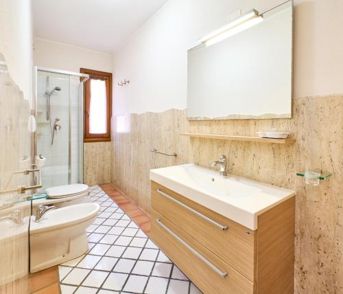 une salle de bain avec un lavabo et des toilettes dans l'établissement Casa Pisano, à Villasimius