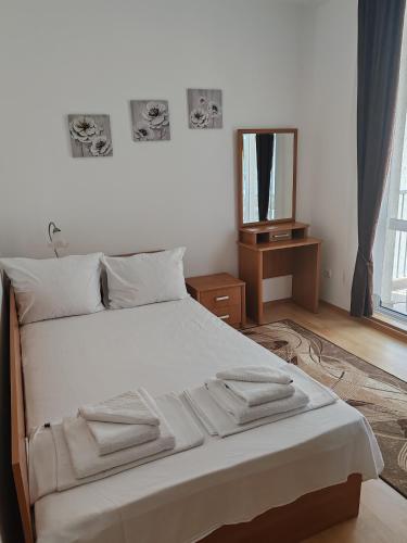a bedroom with a large white bed with a mirror at Kabakum Apartments in Golden Sands