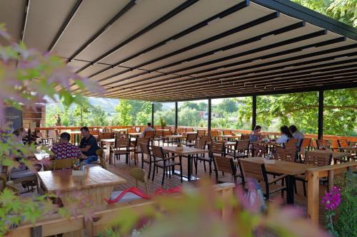 a group of people sitting at tables in a restaurant at Mesopotam Agrotourism Resort in Sarandë