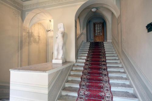 a staircase with a white statue and a red carpet at Hotel Park Lion Bridge in Saint Petersburg