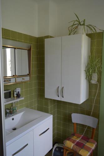 a bathroom with a sink and a white cabinet at Chez Thérèse et Marguerite in Kindwiller