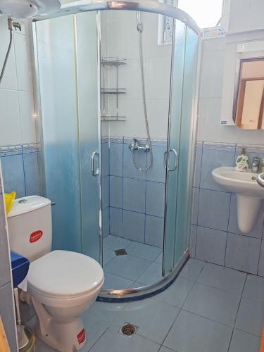 a bathroom with a shower with a toilet and a sink at Kabakum Apartments in Golden Sands