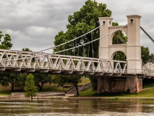 a suspension bridge over a river with water at EVEN Hotel Waco - University Area by IHG in Waco