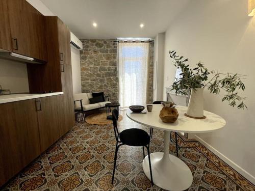une cuisine avec une table et des chaises dans une pièce dans l'établissement Appartement cosy, climatisé et central à deux pas de la mer !, à Carqueiranne