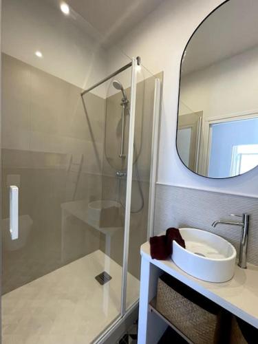 une salle de bain avec une douche, un lavabo et un miroir dans l'établissement Appartement cosy, climatisé et central à deux pas de la mer !, à Carqueiranne