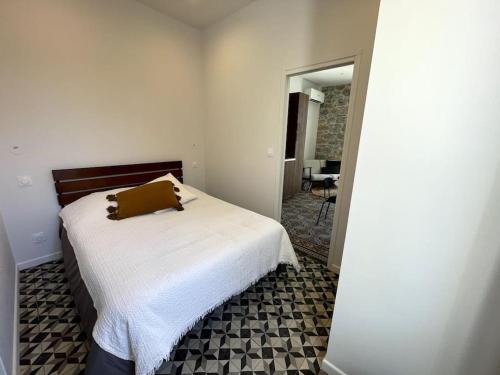 - une chambre avec un lit doté d'un oreiller marron dans l'établissement Appartement cosy, climatisé et central à deux pas de la mer !, à Carqueiranne