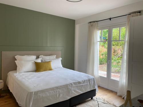 une chambre avec un lit blanc avec une fenêtre dans l'établissement Villa Victoire, à Lège-Cap-Ferret