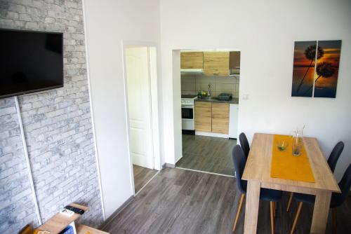 a kitchen and dining room with a table and a television at Apartmani Maslačak in Vrdnik