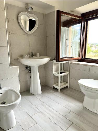 a bathroom with a sink and a toilet and a mirror at Leoncito del Conero in Marcelli
