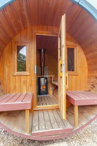 une cabine circulaire avec bancs et cuisinière dans l'établissement Maison atypique avec vue sur la montagne à Montjoie-en-Couserans, à Montjoie-en-Couserans