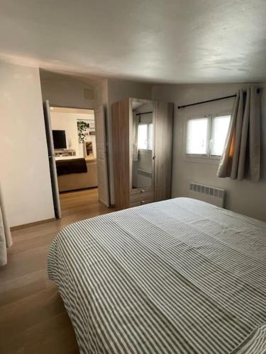 - une chambre avec un lit doté d'une couverture rayée dans l'établissement Charmant T2 en centre-ville, à Ajaccio