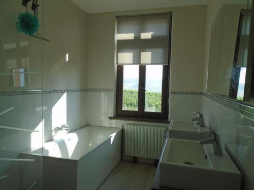 a white bathroom with a sink and a window at maison de famille in Driencourt