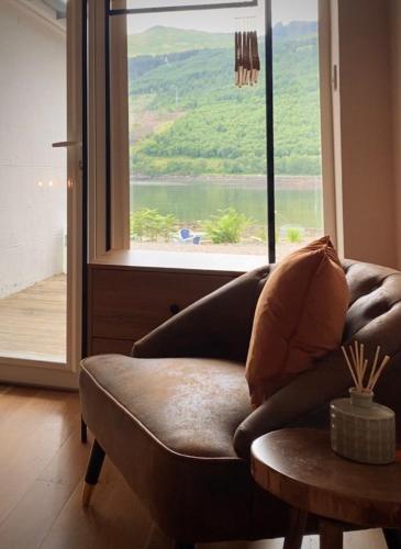 a living room with a couch and a large window at Lochside Guest House in Arrochar
