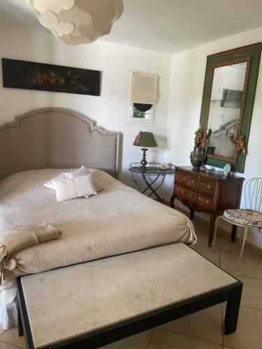 una camera con letto, specchio e tavolo di Maison de Golfeur a Mallemort