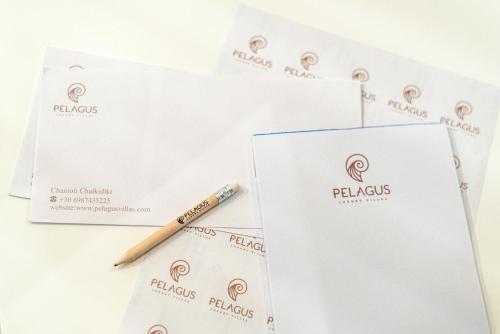 a pencil sitting on top of some white envelopes at Pelagus Luxury Villas in Polykhrono