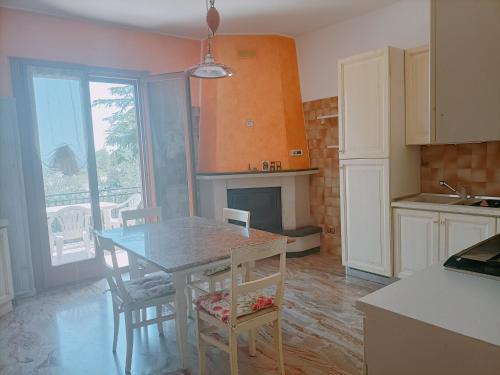 une cuisine avec une table et des chaises ainsi qu'une cheminée dans l'établissement Le Api di PE', à Cupramontana