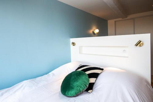 - un oreiller vert assis au-dessus du lit dans l'établissement Valencio - Un belvédère sur le Vieux Lyon, à Lyon