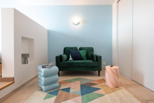 - un salon avec un canapé vert et un tapis coloré dans l'établissement Valencio - Un belvédère sur le Vieux Lyon, à Lyon