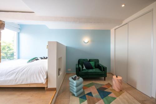 - une chambre avec un lit et une chaise verte dans l'établissement Valencio - Un belvédère sur le Vieux Lyon, à Lyon