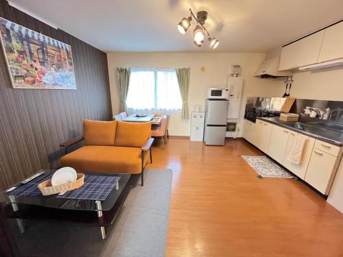 a kitchen and living room with a couch and a table at ロイヤル黒部 in Kurobe