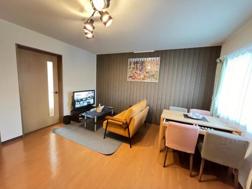 a living room with a table and a dining room at ロイヤル黒部 in Kurobe