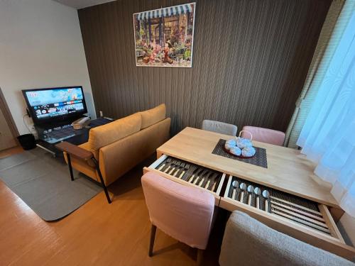 a living room with a table and a television at ロイヤル黒部 in Kurobe