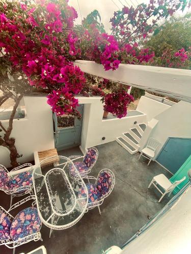 a patio with tables and chairs and flowers at Galanos Katoikies in Órmos Aiyialís