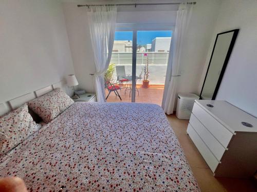 a bedroom with a bed and a view of a balcony at Condado de Alhama, NARANJOS 8 SV25 in El Romero