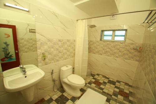 a bathroom with a toilet and a sink at Olive Periyar in Thekkady