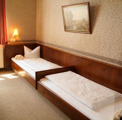 two beds in a room with a picture on the wall at Braugasthof Papiermühle in Jena