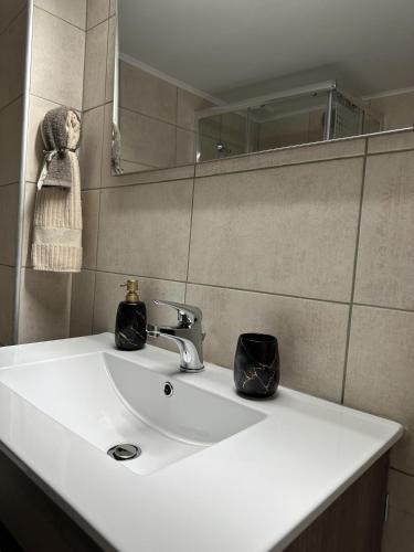 a bathroom with a white sink and a mirror at Piraeus Seaside Apartment Escape in Piraeus