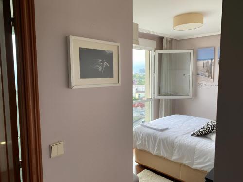 ein Schlafzimmer mit einem Bett und einem Fenster in der Unterkunft Pisazo con Vistas y garaje privado in Maliaño