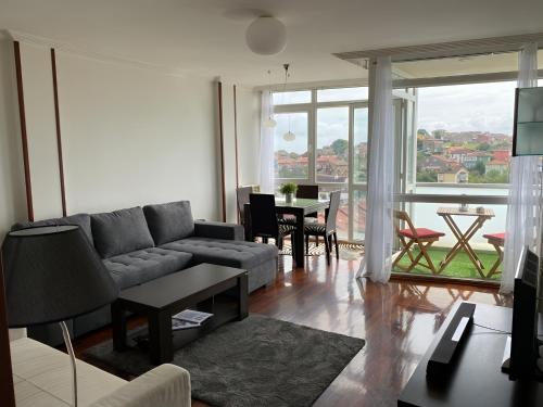 ein Wohnzimmer mit Sofa und Tisch in der Unterkunft Pisazo con Vistas y garaje privado in Maliaño