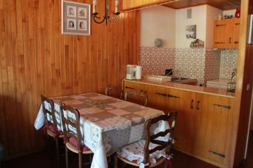 une cuisine avec une table, des chaises et un comptoir dans l'établissement RESIDENCE RSA17 SWIMMING POOL & CENTER 5 pers, à Châtel