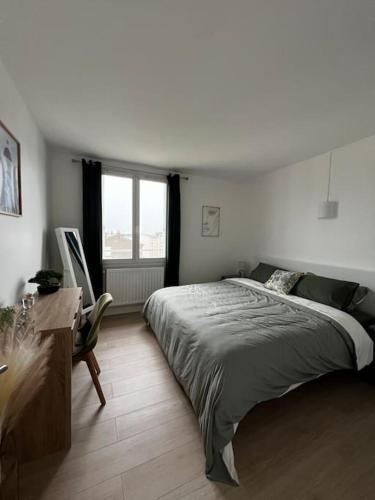 une chambre avec un lit, un bureau et une fenêtre dans l'établissement Appartement La Perle Urbaine, à Bourges